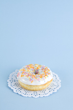 a multicolor donuts presented on a doily paper and a pop colorful background.の写真素材