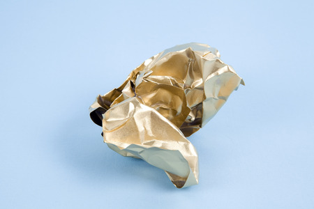a ball of crumpled paper painted in gold. Minimal color still life and quirky photographyの写真素材