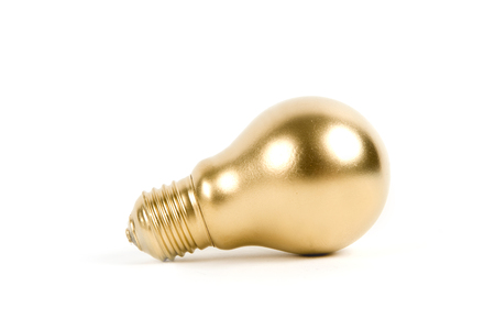 a light bulb painted in gold. Minimal color still life and quirky photography. Minimal color still life and quirky photographyの写真素材