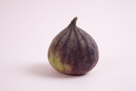 harmony of colors and tones with a fig placed on a pastel pink background. Minimal color still life photography.の写真素材