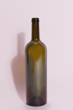 a single brown glass bottle isolated on a pink background. Minimal color still life photographyの写真素材