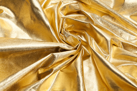 close-up view of a gold piece of fabric like ripples. Luxury composition. Minimal color still life photography. Minimal color still life photographyの写真素材