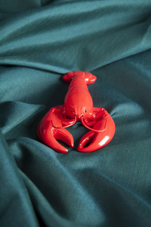 a lobster on a green wavy fabric background. Minimal color still life photography.の写真素材