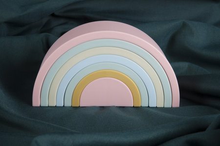 a plastic rainbow toy on a green curtain. Minimal color still life photography.の写真素材
