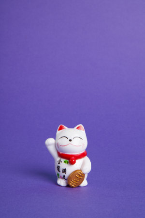 a Maneki-neko plastic cat, Symbolizing luck and wealth, on a pop and colorful background. Minimal trendy color still life photographyの写真素材