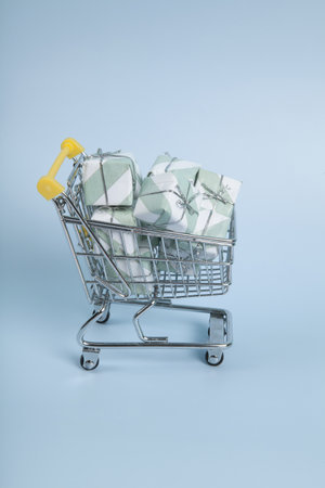 a caddy filled with gifts against a luminous sky-blue background. Minimalist, trendy still life photography.の写真素材