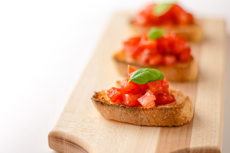 Bruschetta is an italian food made of chopped tomatoes, garlic, basil and fresh herbs on a toasted bread. These are traditionally served as snacks or antipasti (appetizers).の写真素材