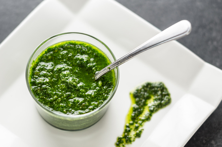 Fresh homemade basil pesto sauce in a glass jar. Originally from italy, pesto is commonly made with basil and used as a sauce for pasta.の写真素材