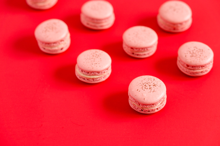 Strawberry macarons on a red background. These romantic french pastries are made of two meringue cookies and a sweet filling. Light & crisp, these are the perfect valentine day dessert.の写真素材