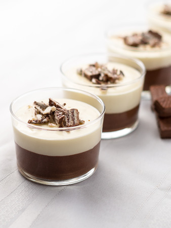 No-bake layered chocolate mousse and cheesecake with chocolate covered wafer cookie crumbs topping. In clear glass dessert bowls. On white background. Great recipe, creamy, light and not too sweet!の写真素材