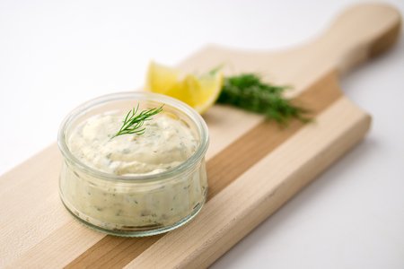 Homemade tartar sauce on white background. Made of fresh mayonnaise, lemon and various herbs. This classic creamy sauce is delicious with deep fried fish, seafood and many other dishes.の写真素材