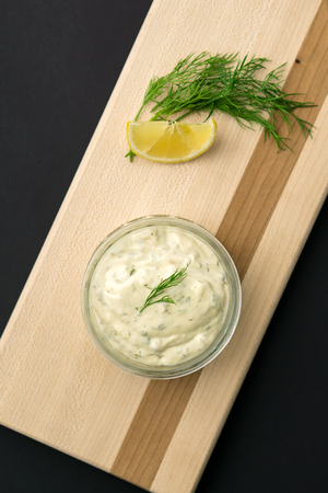 Homemade tartar sauce on black background. Made of fresh mayonnaise, lemon and various herbs. This classic creamy sauce is delicious with deep fried fish, seafood and many other dishes.の写真素材