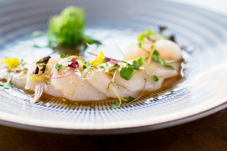 Fresh scallops sashimi closeup. Fresh raw scallops sashimi dish. Sashimi is a Japanese cuisine delicacy consisting of sliced raw meat (usually fish and seafood) often served in sushi restaurants.の写真素材