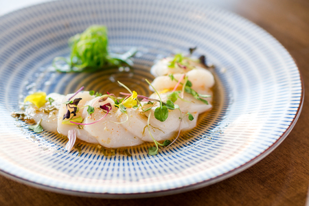 Raw scallops sashimi seafood dish. Fresh raw scallops sashimi dish. Sashimi is a Japanese cuisine delicacy consisting of sliced raw meat (usually fish and seafood) often served in sushi restaurants.の写真素材