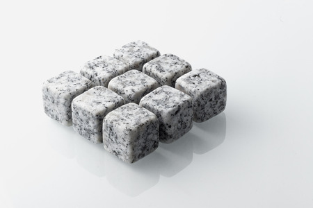 Set of nine spirit chilling stones. Soapstone rocks are carved in cubes to be used as drink chiller (whisky, bourbon ...) Various type of raw minerals produces different colors, such as marbled grey.の写真素材