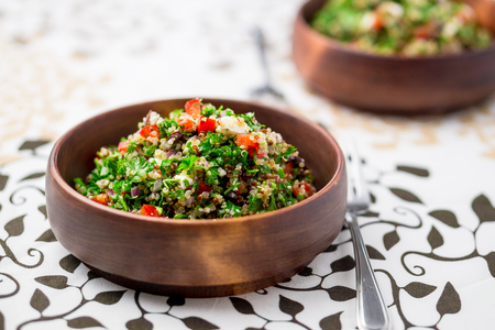 Healthy vegetarian salad bowl. This healthy dish mixes tabbouleh & greek style salads, using fresh parsley herb, olives, onions, feta and replacing the bulgur usually found in tabouleh with quinoa.の写真素材