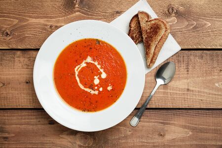 Tomato soup and grilled cheese. A classic comfort food, tomato soup is often enjoyed near summer end or fall. It is a simple and healthy soup using ripe tomatoes, broth and cream sometimes added.の写真素材