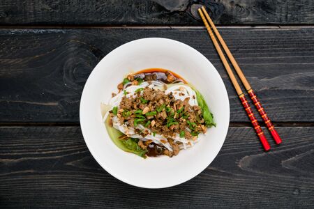 Dan Dan Noodles from above. Dan Dan Noodles is a spicy Szechuan cuisine dish commonly found in chinese street food. Ingredients include thick rice noodles, sichuan pepper, chili oil and ground pork.の写真素材