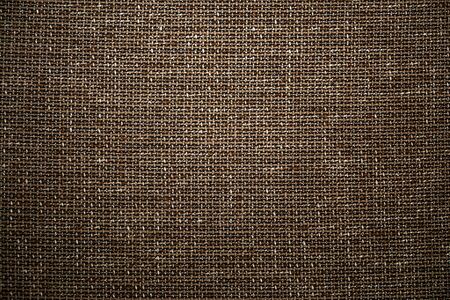 Brown textile fabric background. High resolution close up of brown fabric cloth made of various textile threads. This top view dark fabric background can be used as design element such as backdrop.の写真素材