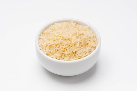 Basmati rice bowl on white background. Rice comes from seeds of grass, it is the most consumed staple food ingredient. Basmati rice is a type of aromatic long grain rice often used in indian cuisine.の写真素材