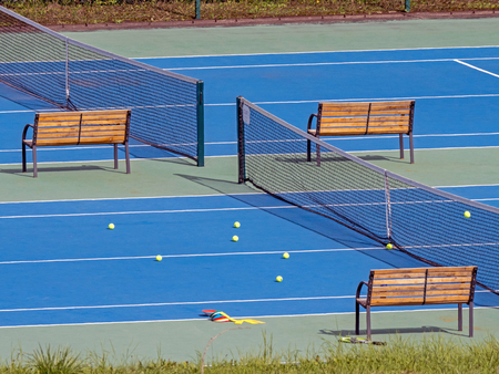 Blue surfaced tennis court with yellow balls during coaching sessionの写真素材