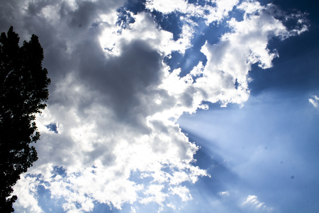 Rays of the sun coming out of the clouds blue skyの写真素材