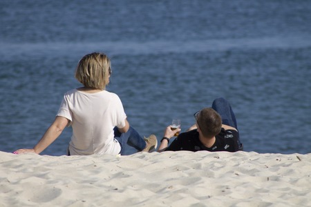 people relax on the beach with drinks man and womanの写真素材