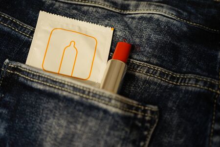 Condom and red lipstick in jeansの写真素材