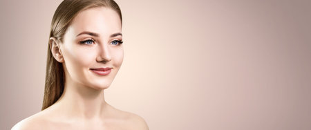 Side view on beautiful girl with perfect makeup and skin. Over beige background.