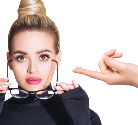 Young woman in glasses decides to wear contact lenses. isolated on white. Glasses or lenses concept.の写真素材