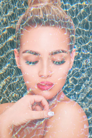 Double exposure portrait of young woman face and blue water pool ripple.の写真素材