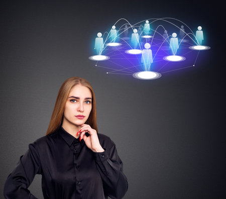 Young businesswoman stands near social media icons. Over gray background.の写真素材