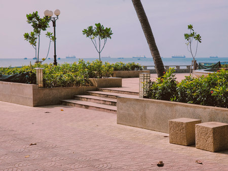 Seaside promenade with landscaping and distant ships