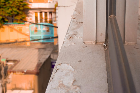 Weathered balcony ledge with peeling paint and urban backgroundの写真素材
