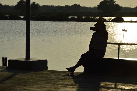 Ban Khun Samut Chin, Samutprakarn, Thailand - November, 21 2019: A woman is taking selfie herself at twilight to keep the moment while traveling the local village home stay.のeditorial素材