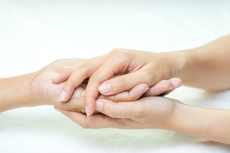 Asian senior and asian young holding hands.の写真素材