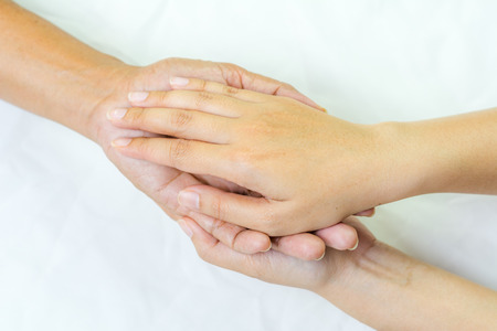 Asian senior and asian young holding hands.の写真素材