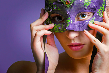 young lady holding a colorful eye mask at her faceの写真素材