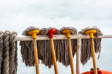 Cleaning mop and rope on the deck of a boat.の写真素材
