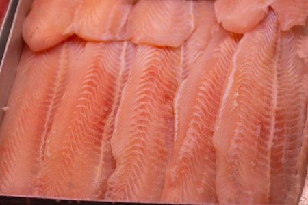 Fish fillets on display in a market, closeup of photo
