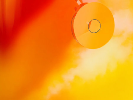 Blank CD or DVD disk on a background of orange sky.の素材