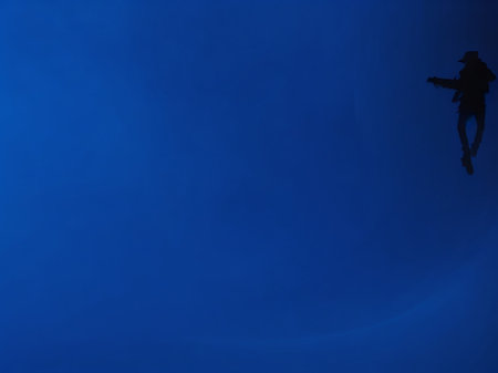 silhouette of a skater in the dark on a blue backgroundの素材