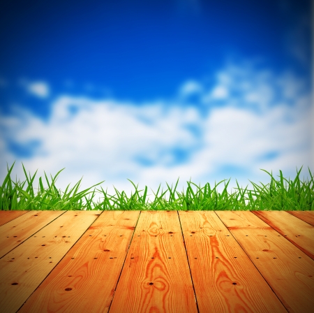 Fresh spring green grass with blue bokeh and sunlight and wood floor  Natural background の写真素材