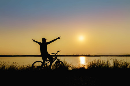 silhouette of cyclist in nature background and beautiful sunsetの写真素材