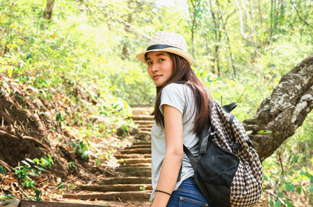Woman traveler walking up level of staircase the cliff on the mountains hiの写真素材