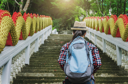Young beauty woman traveler with backpack and hat walking staircase  temple backgroundの写真素材