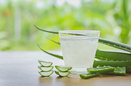 fresh aloe vera leaves and aloe vera juice in glass on wooden backgroundの写真素材