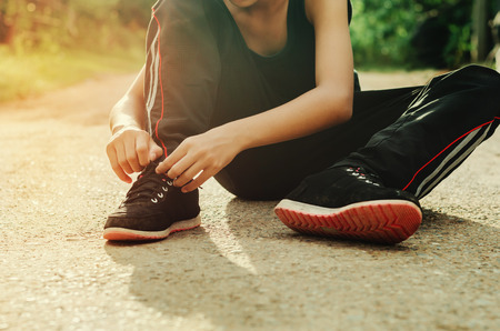 young woman tying sport shoeの写真素材