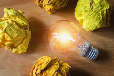 concept crumpled paper around light bulb  on wood for good new ideaの写真素材