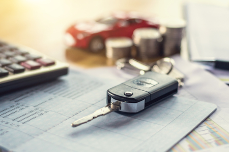 car key with money and calculator on table.の写真素材